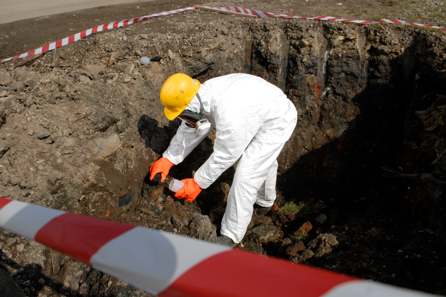 Чоловік у касці збирає зразки ґрунту